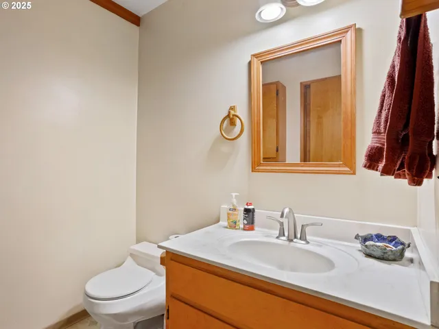 a bathroom with a granite countertop sink vanity mirror and toilet