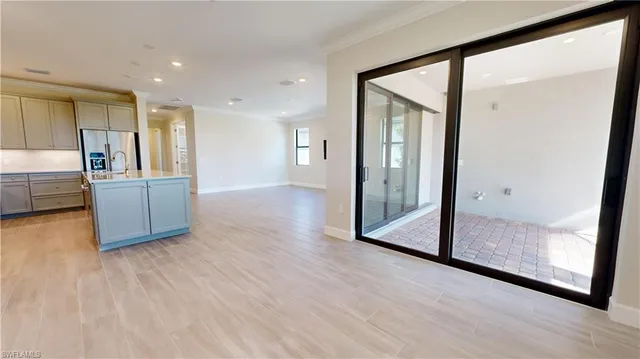 a view of a kitchen with wooden floor and a hallway