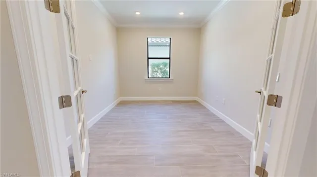a view of an empty room with wooden floor and stairs