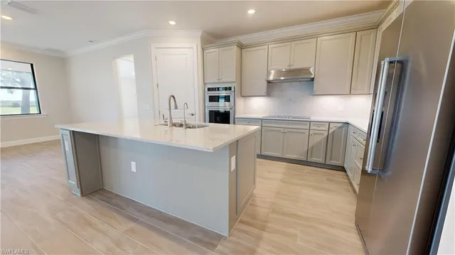 a kitchen with stainless steel appliances a refrigerator sink and stove