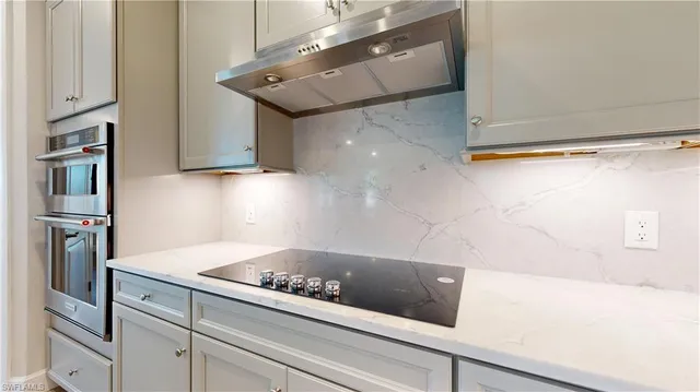 a kitchen with a refrigerator and a stove top oven