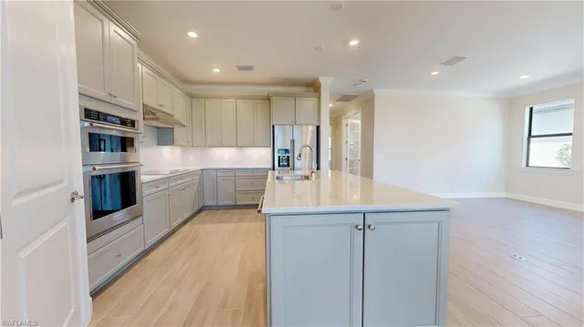 a kitchen with kitchen island granite countertop a sink and cabinets