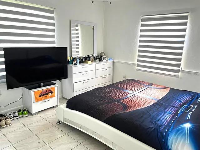 a living room with a bed furniture and a flat screen tv