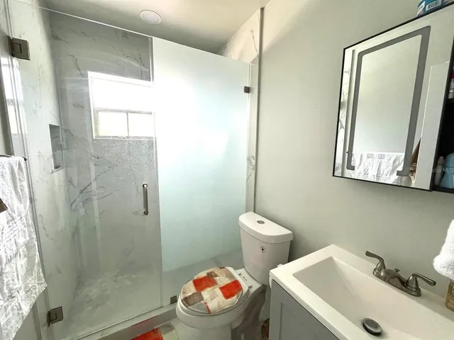 a bathroom with a sink mirror toilet and shower