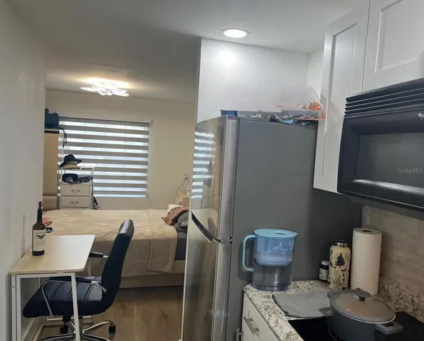 a view of a house with a yard and palm trees