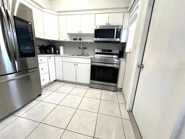 a kitchen with stainless steel appliances a refrigerator stove microwave and sink