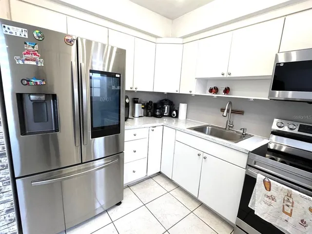 a kitchen with stainless steel appliances a refrigerator sink and cabinets