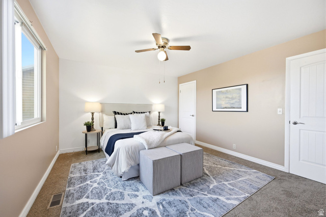 734 Sandy Dunes Drive Sandy, UT 84094 - Photo 18 of 36 Primary Bedroom featuring neutral paint tones, a large window, a ceiling fan with integrated lighting, and a his and hers closet