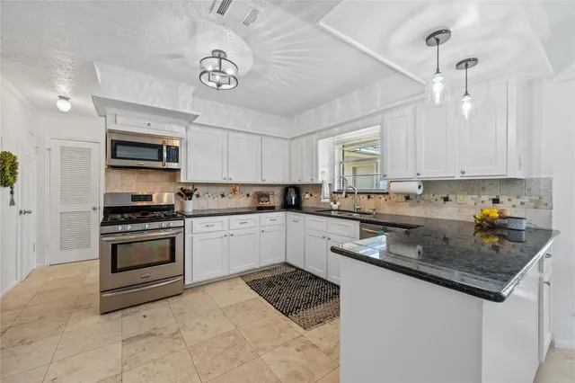 a kitchen with stainless steel appliances granite countertop a stove and a sink
