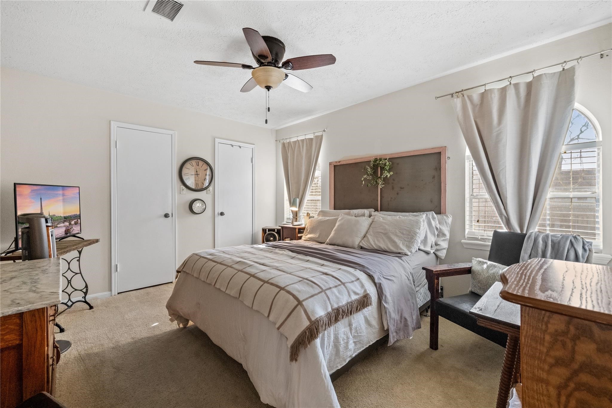 19702 Sweet Forest Lane Humble, TX 77346 - Photo 19 of 30 This cozy bedroom features neutral tones with ample natural light from two windows. The room has two doors, one likely leading to a closet, and is carpeted for added warmth.