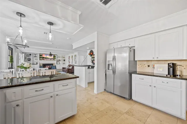 a kitchen with kitchen island white cabinets and refrigerator