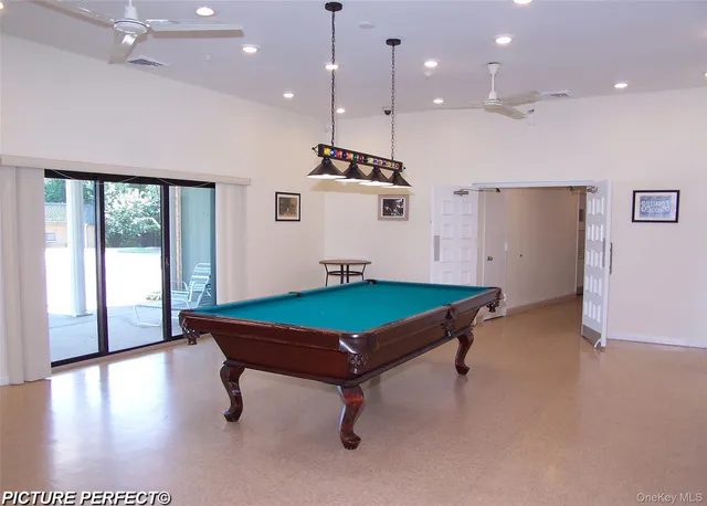 a room with pool table and windows