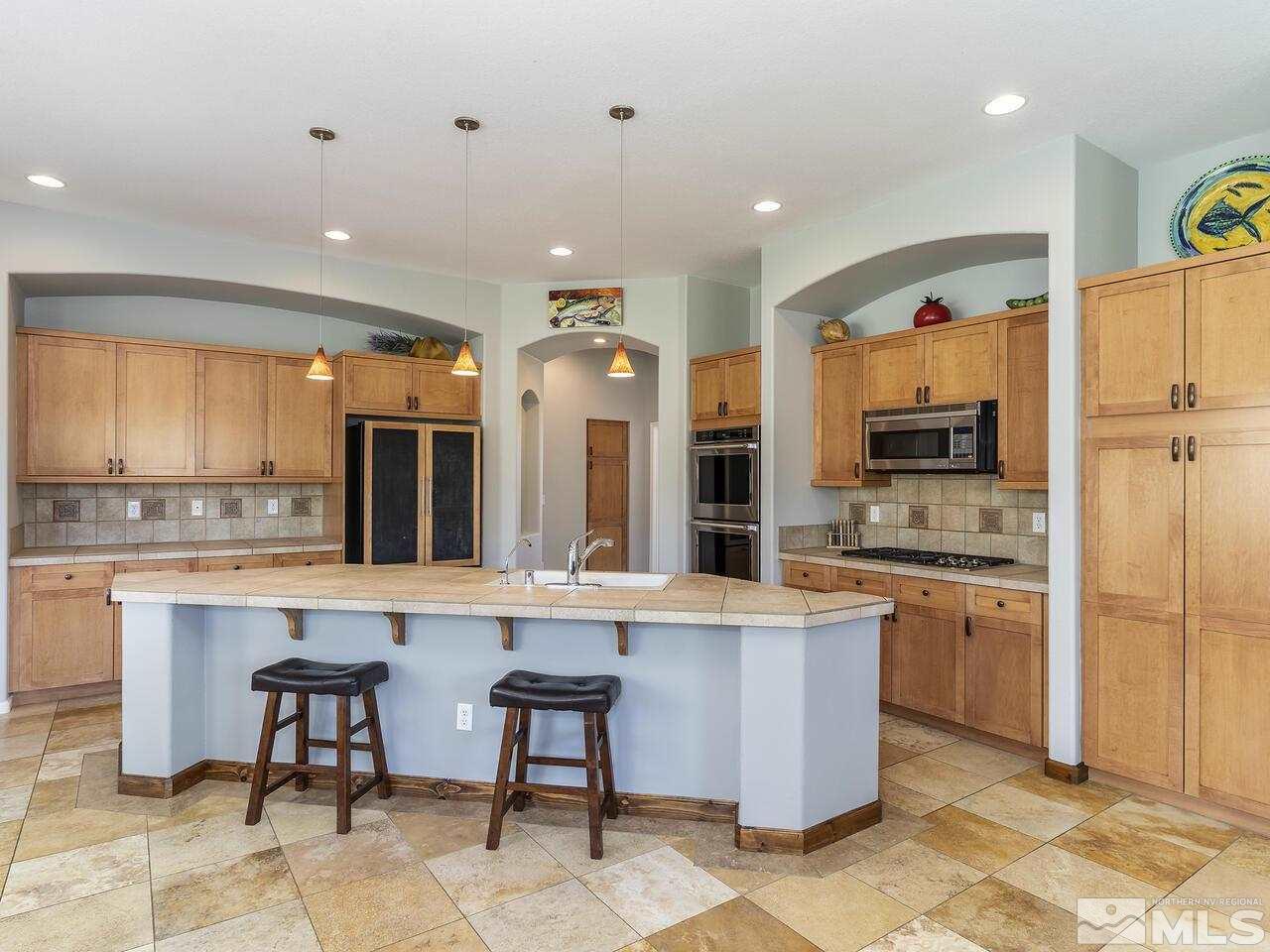 895 Peacepipe Loop Reno, NV 89511 - Photo 13 of 37 a large kitchen with stainless steel appliances granite countertop a stove and a sink