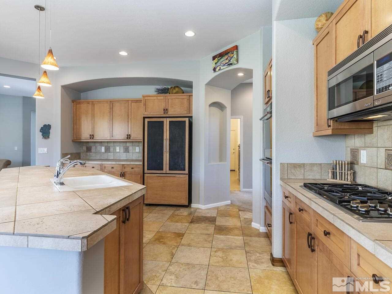 895 Peacepipe Loop Reno, NV 89511 - Photo 14 of 37 a kitchen with stainless steel appliances granite countertop a sink stove and refrigerator