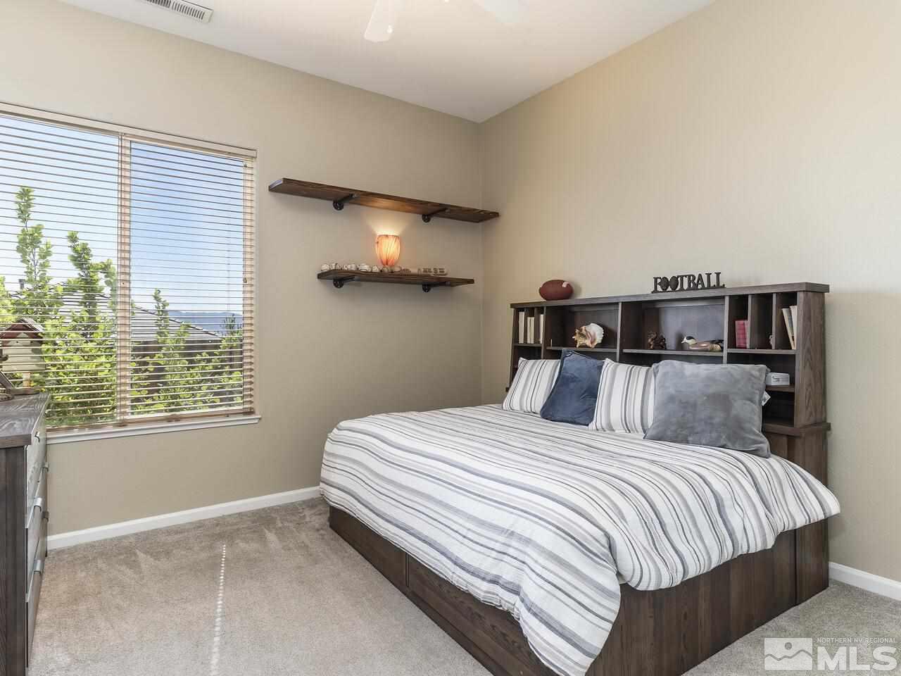 895 Peacepipe Loop Reno, NV 89511 - Photo 20 of 37 a bed sitting in a bedroom next to a window