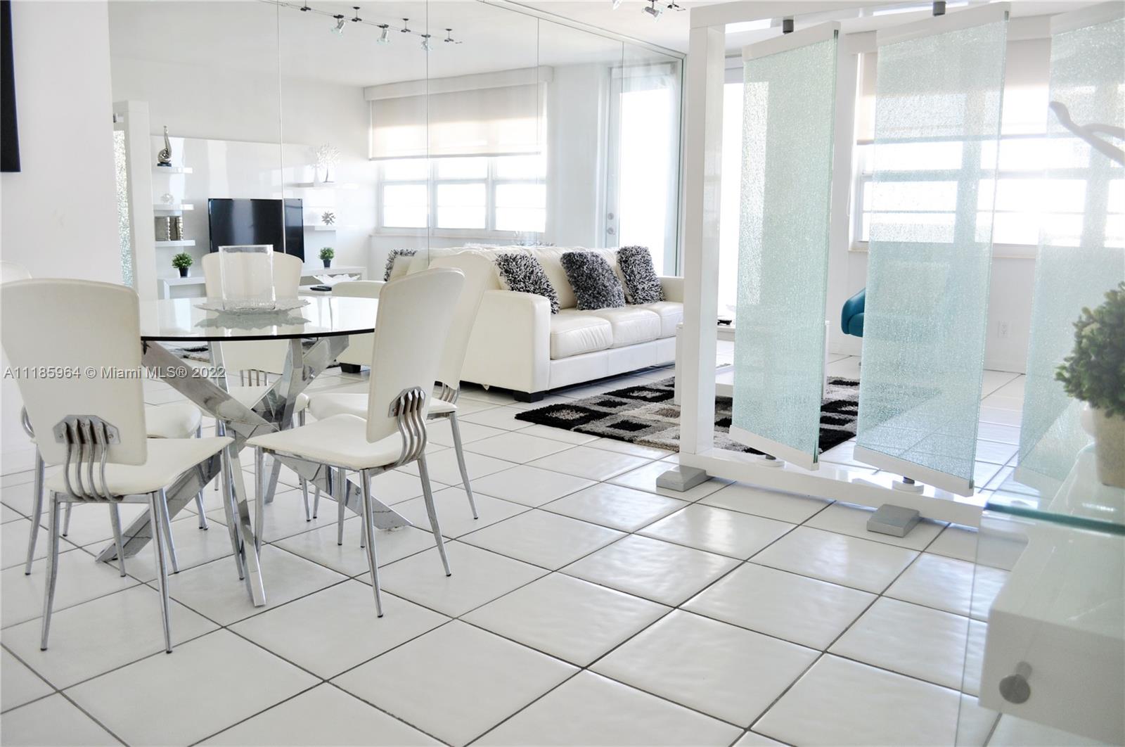 100 Lincoln Road, Unit 910 Miami Beach, FL 33139 - Photo 3 of 10 a living room with furniture a flat screen tv and a large window