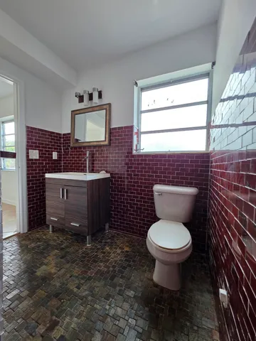 a bathroom with a toilet a sink and mirror