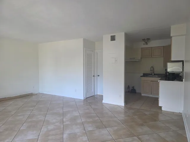 a view of kitchen with granite countertop cabinets and white appliances