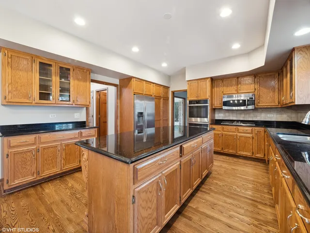 a large kitchen with stainless steel appliances granite countertop a stove and cabinets