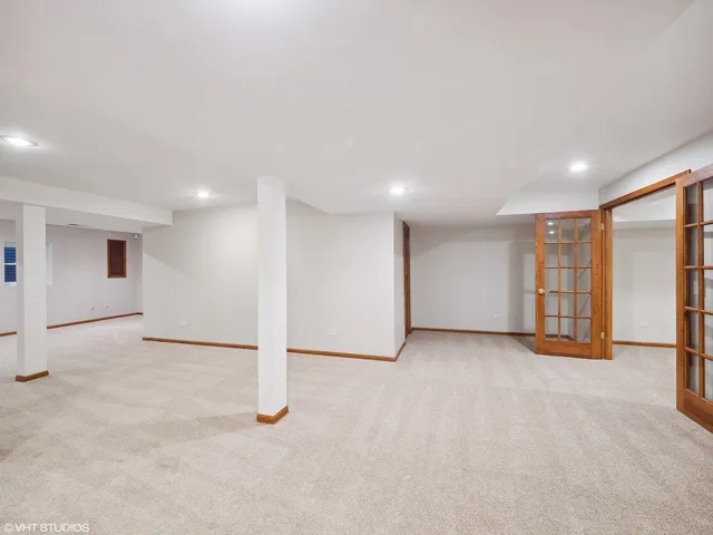 a view of an empty room with stairs and windows