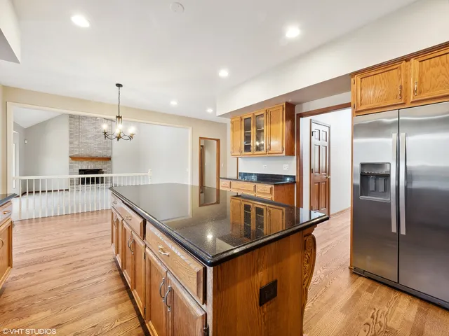 a kitchen with stainless steel appliances granite countertop a refrigerator a sink and a stove