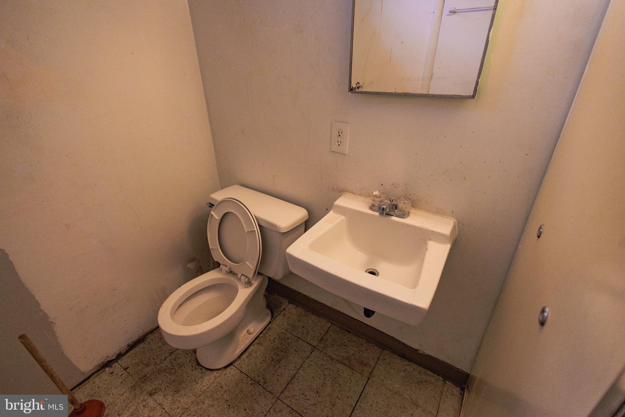 213 Laurel Avenue, Unit B Glassboro, NJ 08028 - Photo 24 of 24 a bathroom with a toilet sink and mirror