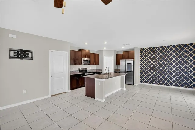 a kitchen with stainless steel appliances kitchen island granite countertop a refrigerator sink and cabinets
