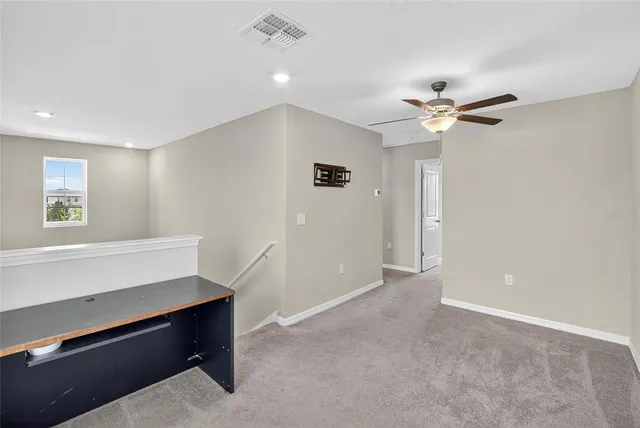 a view of room with hardwood floor and a ceiling fan