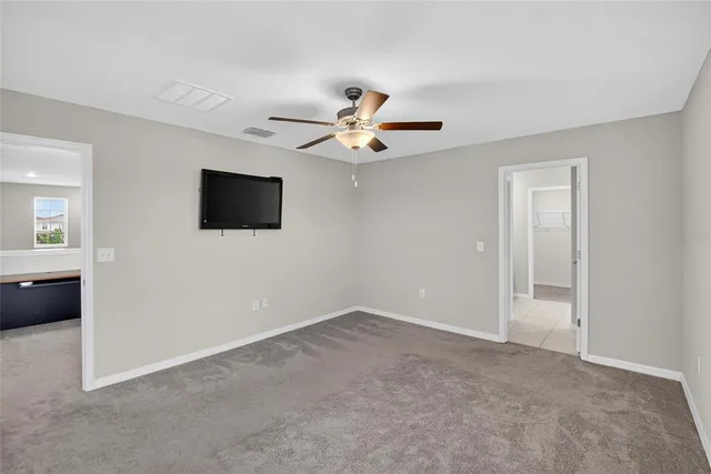 a view of a livingroom with a flat screen tv and a ceiling fan