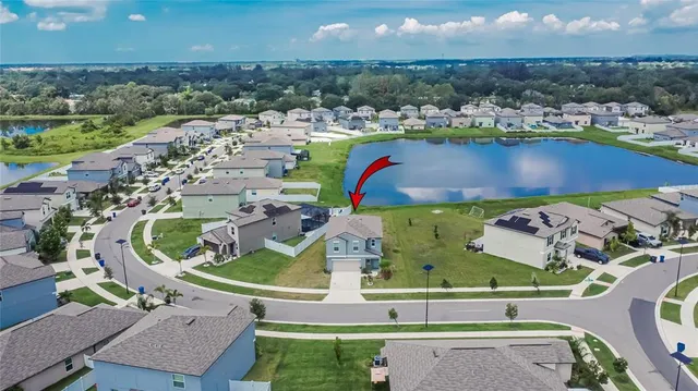 an aerial view of a house with a yard and lake view