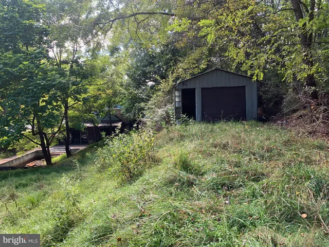 a view of a backyard with couches with wooden fence and floor