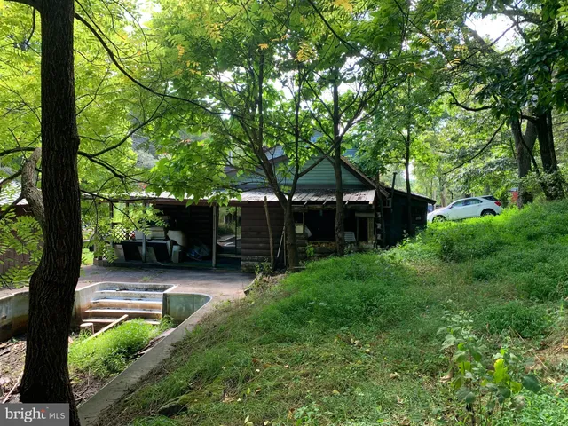 a view of a white house with a yard and stairs