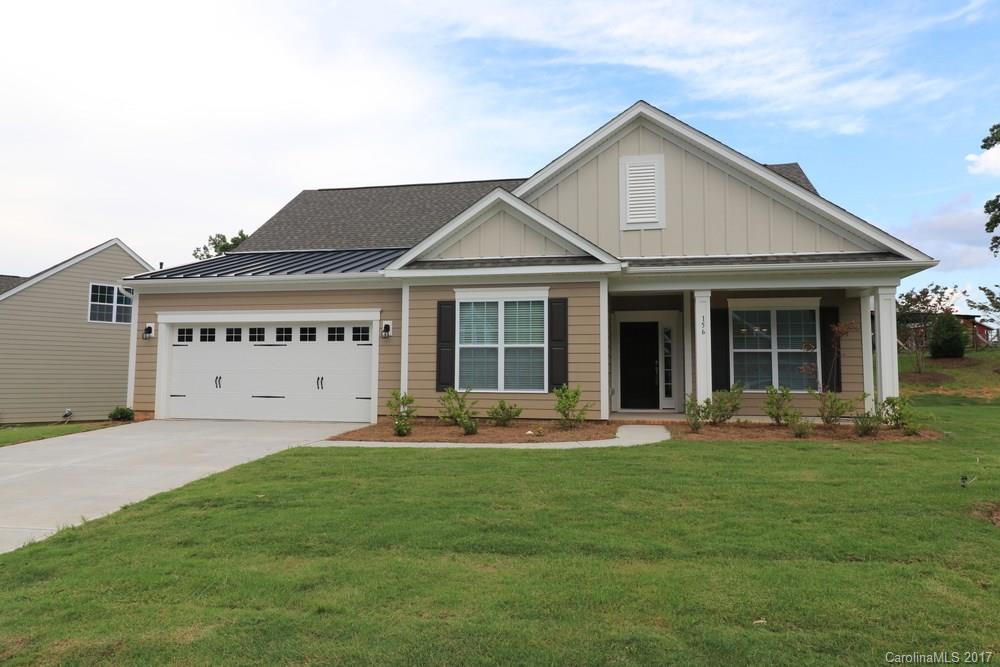a front view of a house with a garden and trees