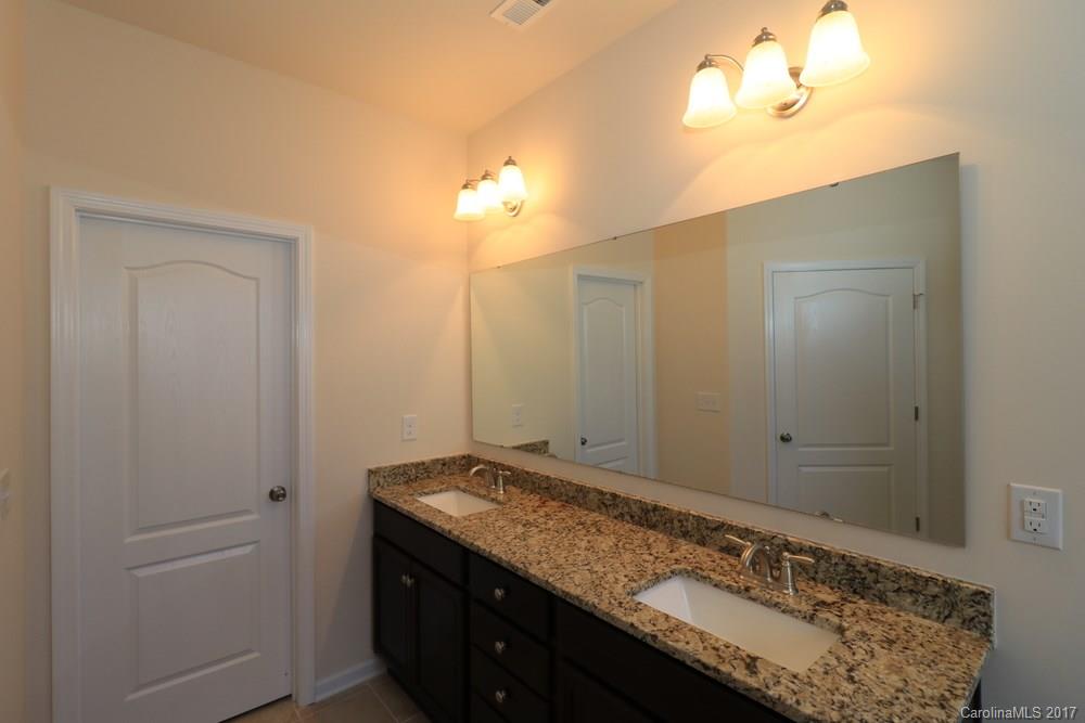 156 Hawks Creek Parkway, Unit 16 Fort Mill, SC 29708 - Photo 12 of 21 a bathroom with a granite countertop sink and a mirror