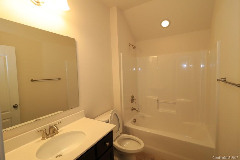 156 Hawks Creek Parkway, Unit 16 Fort Mill, SC 29708 - Photo 18 of 21 a bathroom with a granite countertop sink a toilet and shower