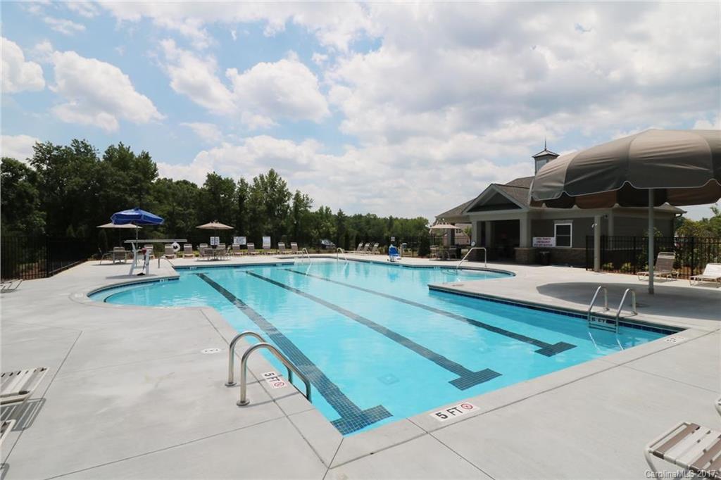 156 Hawks Creek Parkway, Unit 16 Fort Mill, SC 29708 - Photo 20 of 21 a view of swimming pool that has lawn chairs with plants and trees
