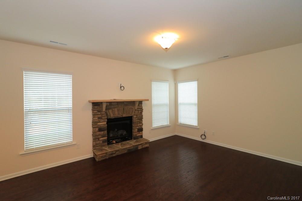 156 Hawks Creek Parkway, Unit 16 Fort Mill, SC 29708 - Photo 10 of 21 an empty room with wooden floor fireplace and windows