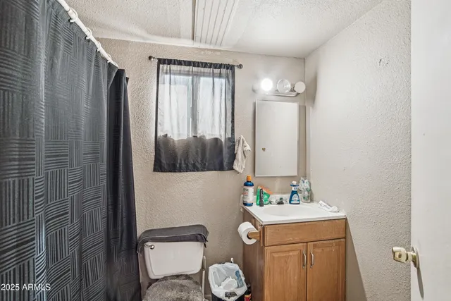 a bathroom with a granite countertop sink toilet and shower