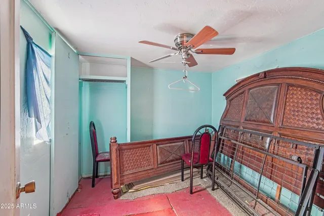 a view of a hallway with furniture and a ceiling fan