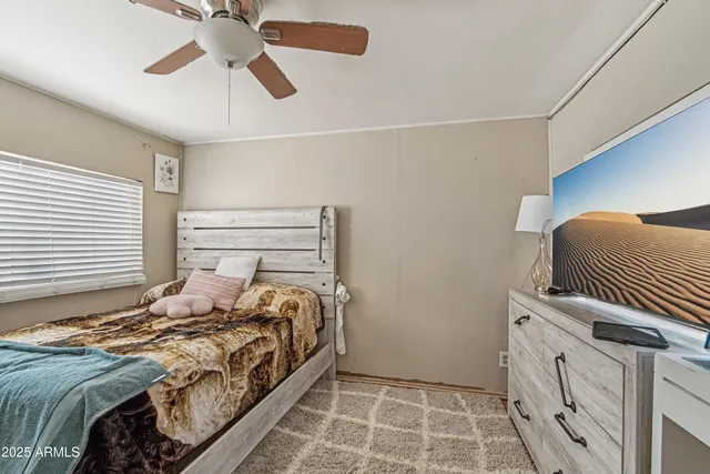 a bedroom with a bed and a chandelier fan