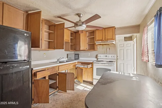a kitchen with a refrigerator sink and cabinets