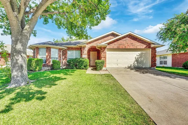 a front view of a house with a yard and trees