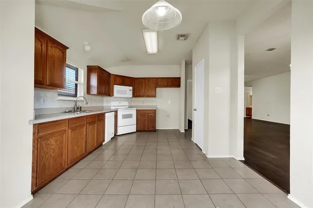 a large kitchen with stainless steel appliances granite countertop a sink and cabinets