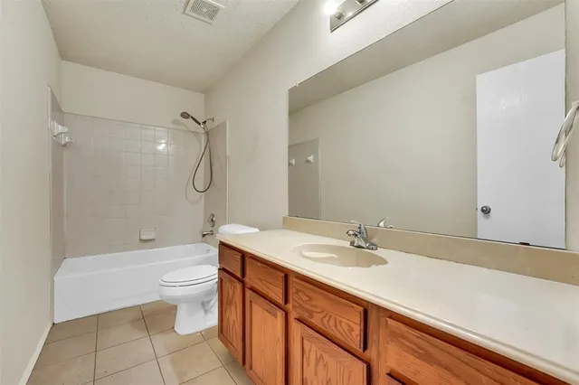a bathroom with a granite countertop sink a toilet and shower
