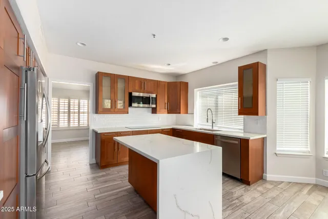 a kitchen with stainless steel appliances granite countertop a sink stove and refrigerator