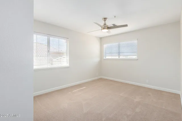 an empty room with fan and windows
