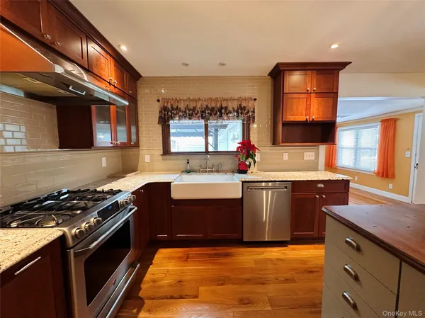 a kitchen with stainless steel appliances granite countertop a stove a sink and a microwave