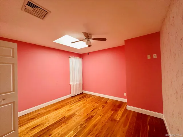 an empty room with a window and a ceiling fan
