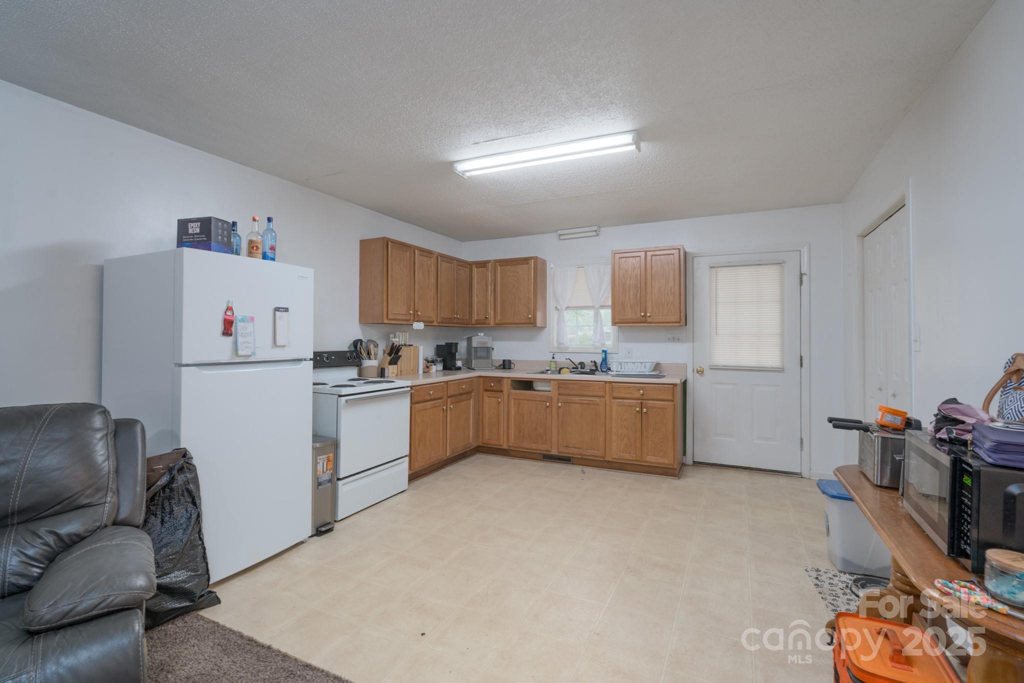 5624 Pleasant Avenue, Unit 3 Fort Lawn, SC 29714 - Photo 13 of 24 a kitchen with a refrigerator a sink dishwasher with a dining table and chairs