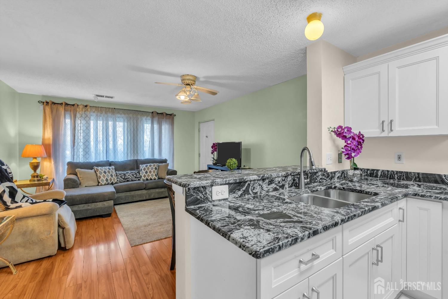 1014 Edpas Road New Brunswick, NJ 08901 - Photo 11 of 27 a kitchen with granite countertop a sink dishwasher a stove and a dining table with wooden floor